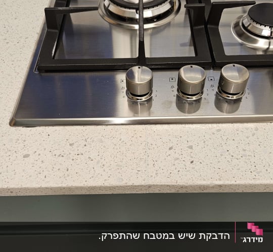 משטח שיש בהיר ליד כיריים גז